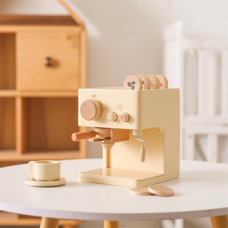 Wooden toy coffee machine with cup and saucer on a white play table